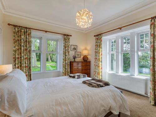 - une chambre avec un grand lit blanc et des fenêtres dans l'établissement 2 Bed in Kirriemuir 86235, à Logie