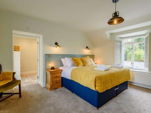 a bedroom with a blue bed and a window at 4 Bed in Oswestry 87477 in Llansilin