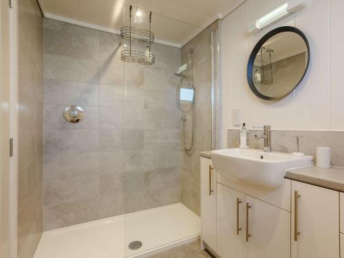 a bathroom with a shower and a sink and a mirror at 2 Bed in Portree 87578 in Portree