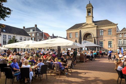 a crowd of people sitting in chairs at tables in front of a building at Huisje Novea in Harderwijk