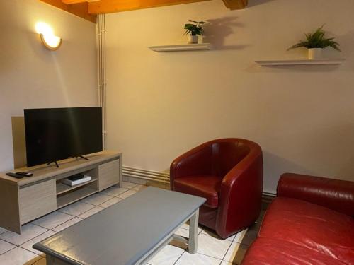 a living room with a couch and a television at La Boussole in Étretat