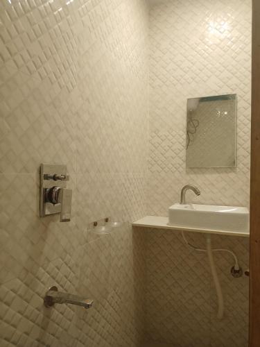 a white bathroom with a sink and a mirror at Hotel Geetanjali St Bus Stand Panvel in Panvel
