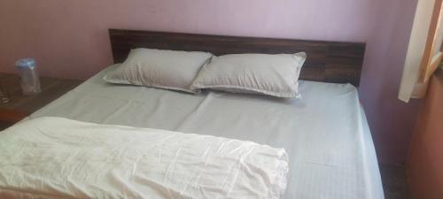 a bed with white sheets and two pillows at Kullvi hill homestay in Shamshi