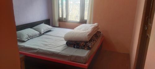 a small bed with two pillows on top of it at Kullvi hill homestay in Shamshi