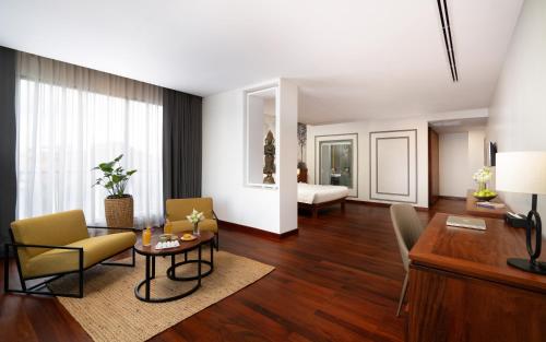 a living room with a table and chairs and a bedroom at Koulen Central Hotel in Siem Reap