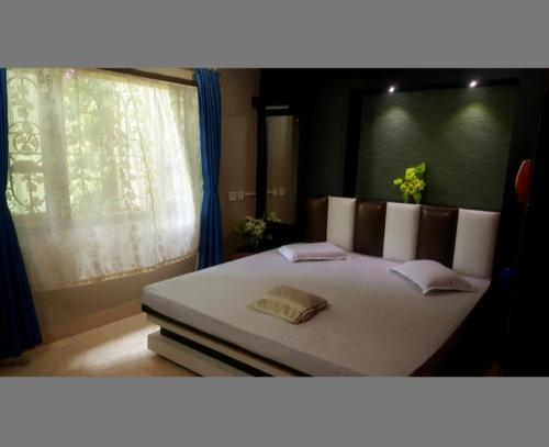 a bedroom with a large white bed with a window at Hotel Mountain View in Kalimpong