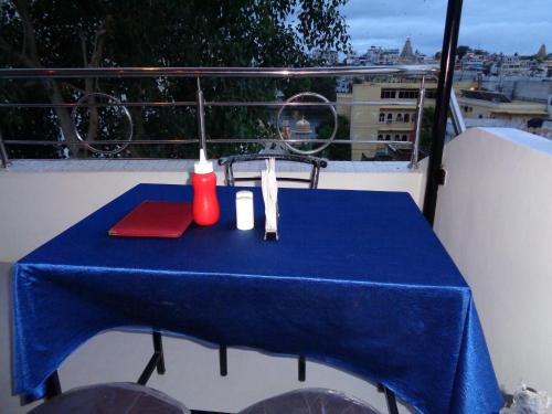 a table with a blue table cloth on a balcony at The Royal Lake View Villa in Udaipur