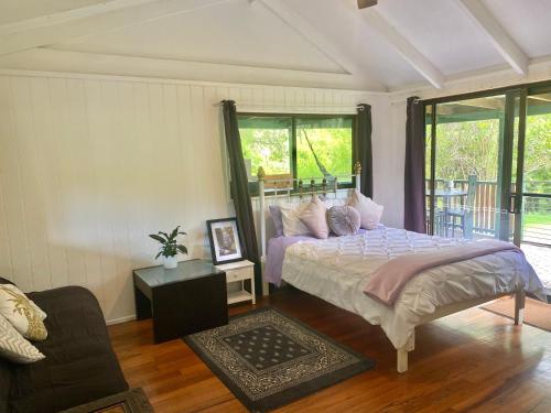 a bedroom with a bed and a couch at Nimbin waterfall retreat in Nimbin