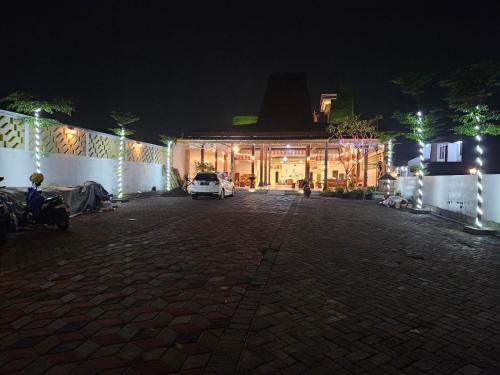um edifício com um carro estacionado em frente dele à noite em Omah Joglo Bugis em Wendit