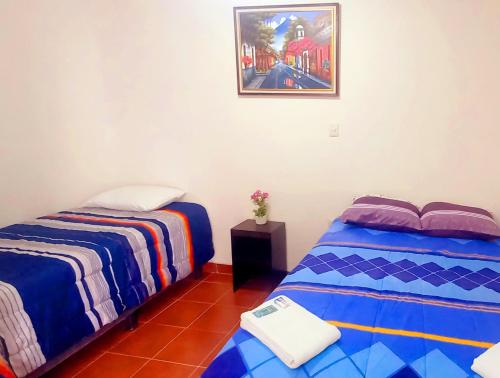 a room with two beds and a picture on the wall at Hotel Maya America in Panajachel