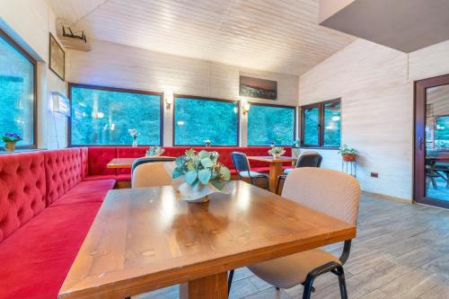 una camera con tavolo e divano rosso di Resort 7 Crai - Cabana Craiul Crailor a Zărneşti