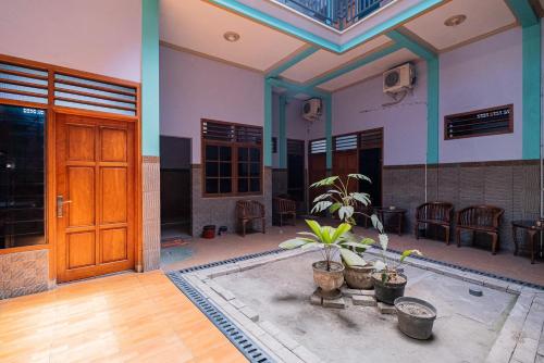 a room with a wooden door and some plants at RedDoorz Syariah near Alun-Alun Bojonegoro in Bojonegoro