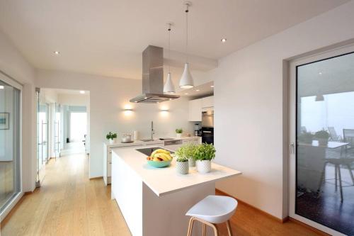 una cucina con banconi bianchi e piano di lavoro di Elegantes Haus zum Wohlfühlen a Vienna