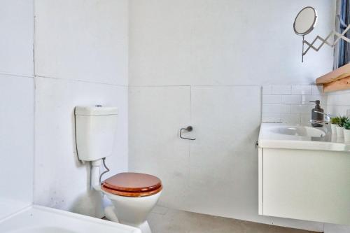 a white bathroom with a toilet and a sink at Unique 2 Bedroom House Pyrmont 2 E-Bikes Included in Sydney