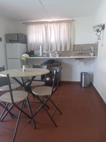 a kitchen with a table and chairs in a room at Brandwag Pool Room in Prieska