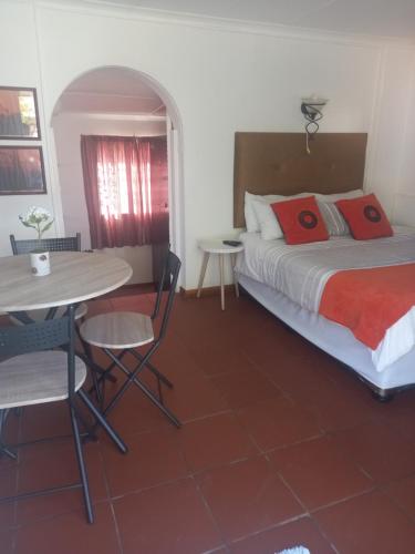 una camera con letto e tavolo e sedie di Brandwag Pool Room a Prieska