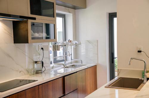 a kitchen with two sinks and a counter top at Villa Sapphire9 Aria Vungtau in Xa Thang Nhut