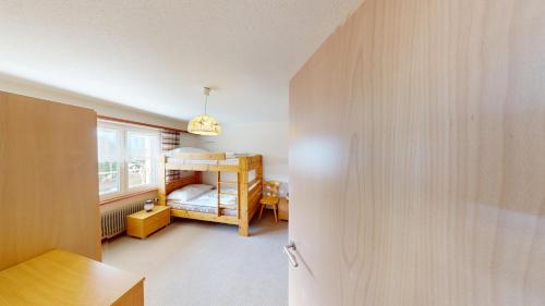 a small room with a bunk bed and a window at Floralpina FL1 in Blatten bei Naters