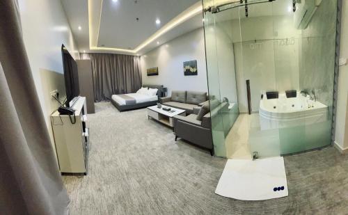 uma sala de estar com um sofá, uma cama e uma banheira em قمم بارك الباحة Qimam Park Hotel 7 em Al Baha