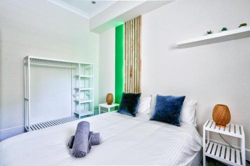 a bedroom with a white bed with blue pillows at Gorgeous 2 Bedroom House Ultimo 2 E-Bikes Included in Sydney