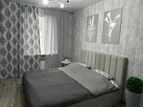 ein Schlafzimmer mit einem Bett in einem Zimmer in der Unterkunft Paradise in Tastybulak