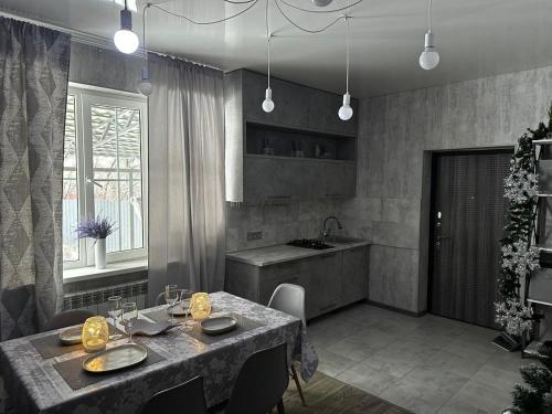 eine Küche mit einem Tisch mit Stühlen und einem Waschbecken in der Unterkunft Paradise in Tastybulak