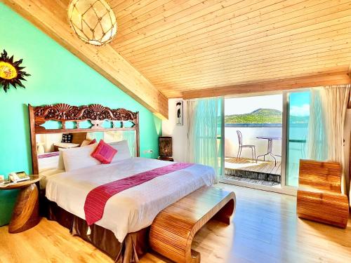 una camera con un grande letto e un balcone di Seasons Bali Fashion Inn a Kenting