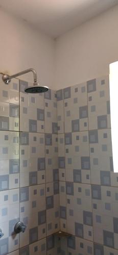 y baño con ducha y pared de azulejos. en M&R Property., en Ukunda