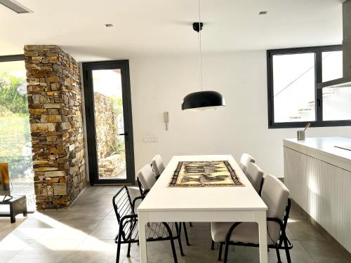 a dining room with a white table and chairs at Magnífica casa con encanto en Agua Amarga in Agua Amarga
