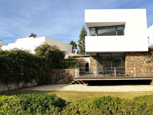 uma grande casa branca com uma parede de pedra em Magnífica casa con encanto en Agua Amarga em Agua Amarga