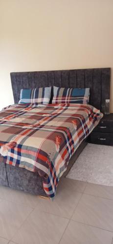 Una cama con manta y almohadas. en M&R Property., en Ukunda