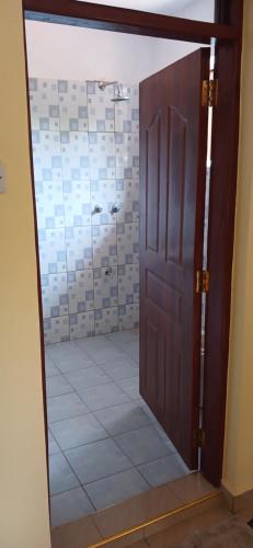 - Puerta a un baño con suelo de baldosa en M&R Property., en Ukunda