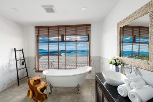 a bathroom with a tub and a large window at Luxury Blue Coco Sea View Villa - 4x4 SUV included in Koh Samui 