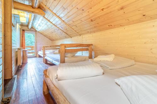 - une chambre avec 2 lits dans une cabane en bois dans l'établissement Resort 7 Crai - Cabana Baciu, à Zărneşti