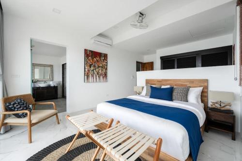una camera con un grande letto e una sedia di Luxury Blue Coco Sea View Villa - 4x4 SUV included a Ko Samui