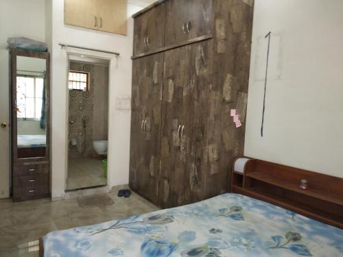 1 dormitorio con 1 cama y pared de madera en Alok Premanand's House en Raipur