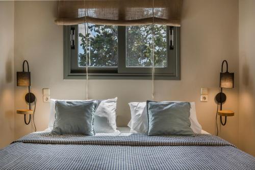 ロウダータにあるUnique Kefalonia Ionian Beach Villaのベッドルーム1室(枕2つ、窓付)