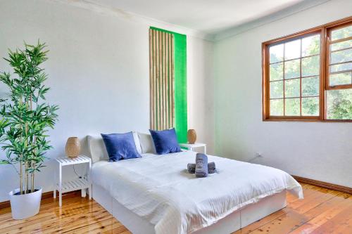 een witte slaapkamer met een bed en een raam bij Elegant House Chippendale - City Center 2 E-Bikes Included in Sydney