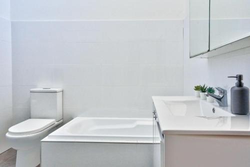 een witte badkamer met een toilet en een wastafel bij Elegant House Chippendale - City Center 2 E-Bikes Included in Sydney