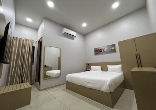 1 dormitorio con 1 cama grande y espejo en Ixoras Hotel Victoire, en Kinshasa