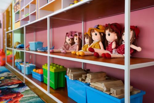 a group of dolls sitting on shelves in a toy store at Emerald Faarufushi Resort & Spa - Deluxe All Inclusive in Raa Atoll