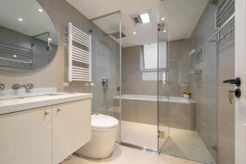a bathroom with a toilet and a shower and a sink at Four-Bedroom Apartment, The Bund View with Branded Appliances in Shanghai