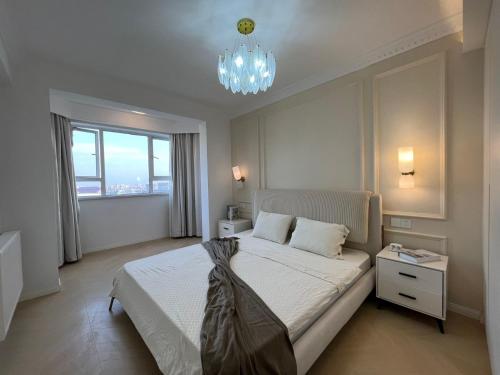 Four-Bedroom Apartment, The Bund View with Branded Appliances في شانغهاي: غرفة نوم بسرير كبير وثريا