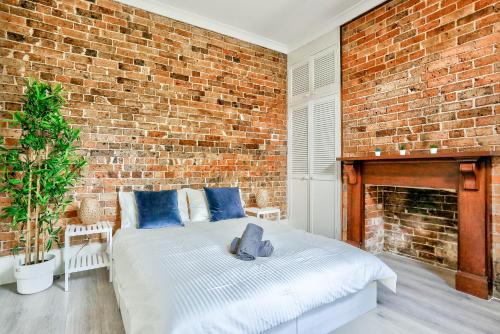 a bedroom with a brick wall and a bed at Comfortable 2 Bedroom House Paddington 2 E-Bikes Included in Sydney