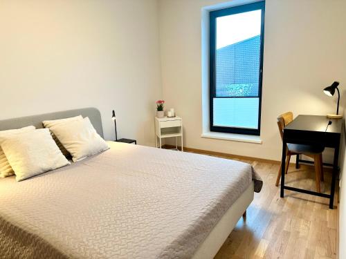 Schlafzimmer mit einem Bett, einem Schreibtisch und einem Fenster in der Unterkunft Riia 22 Apartment in Tartu