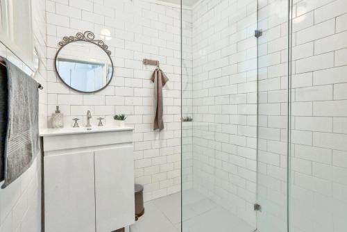 a white tiled bathroom with a sink and a shower at 2 Bedroom House Darling Harbour Kent St in Sydney