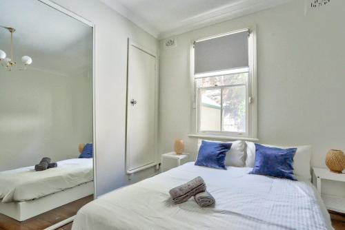 a bedroom with a mirror and a bed with blue pillows at 2 Bedroom House Darling Harbour Kent St in Sydney
