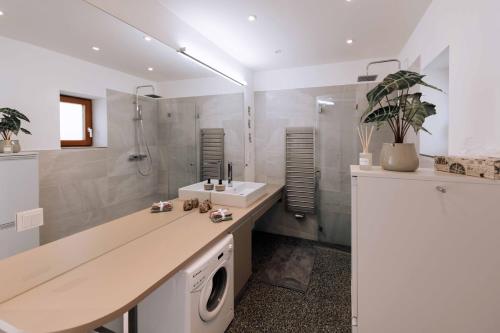 een badkamer met een wastafel en een wasmachine bij Nina´s Home in Gablitz
