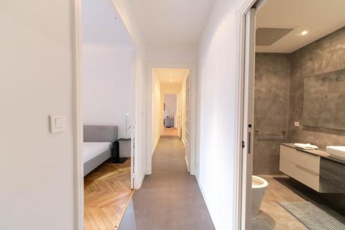 un couloir blanc avec une chambre et une salle de bains dans l'établissement Superbe appartement avec jardin piscine, garage, à Nice