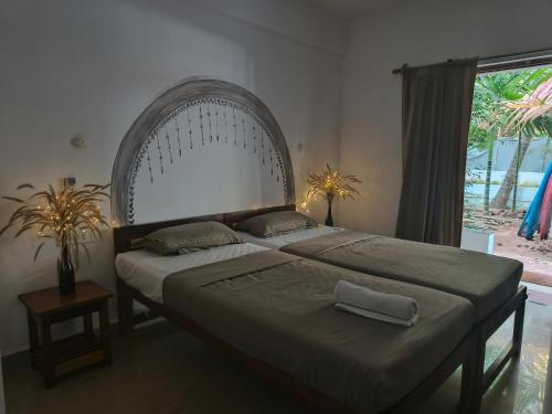 a bedroom with a large bed and a large window at SHANKAR by the SEA, 2 min from Mandrem Beach in Mandrem